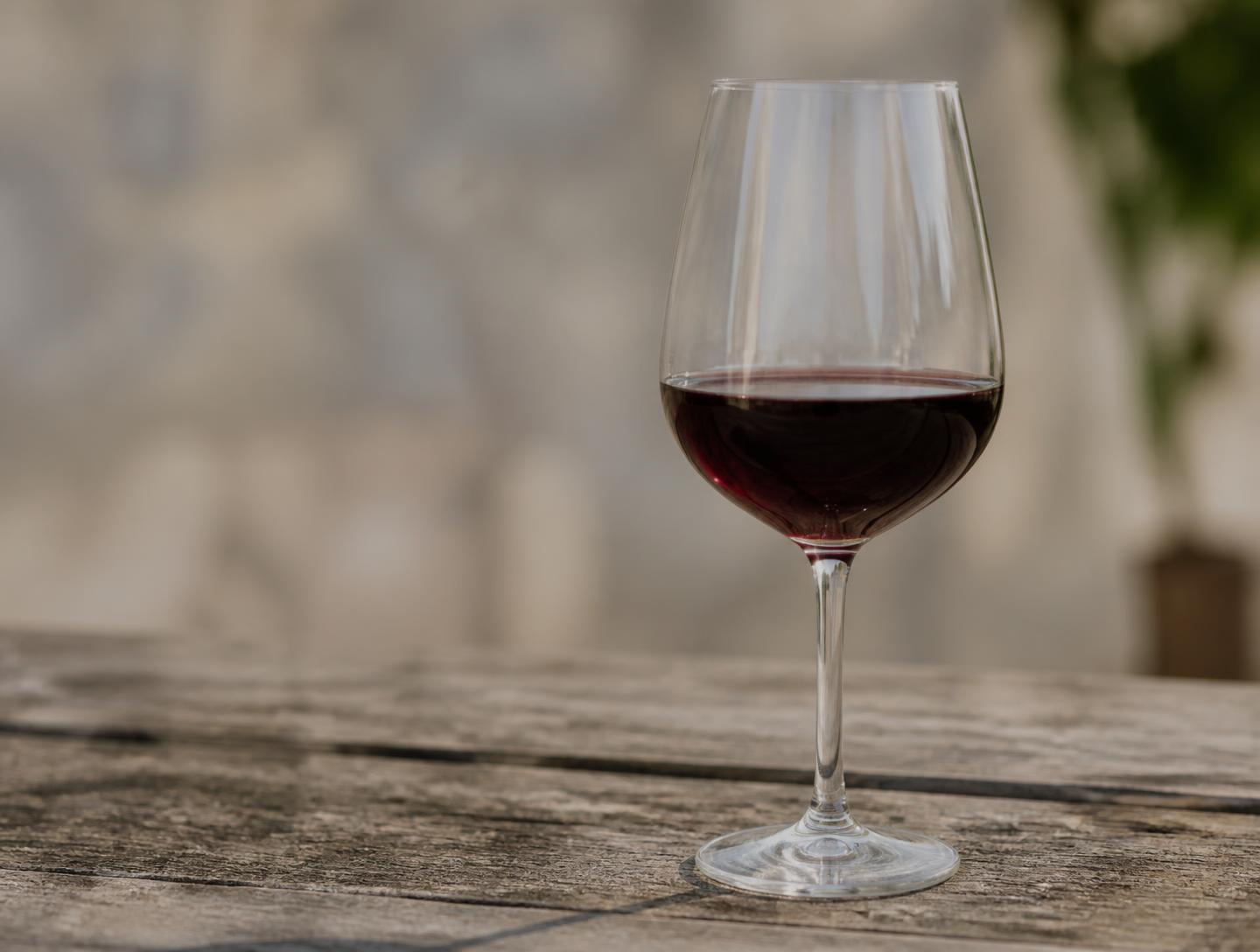A glass of red wine on a weathered wooden table